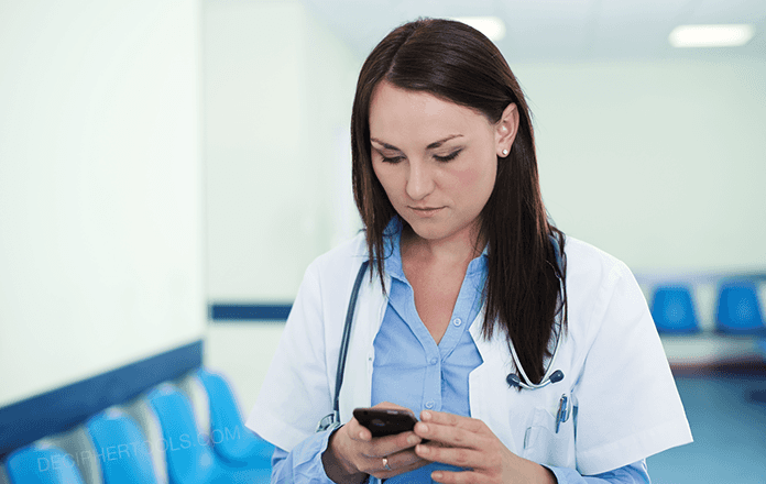 Doctor using her smart phone at work to send work text messages in a hospital